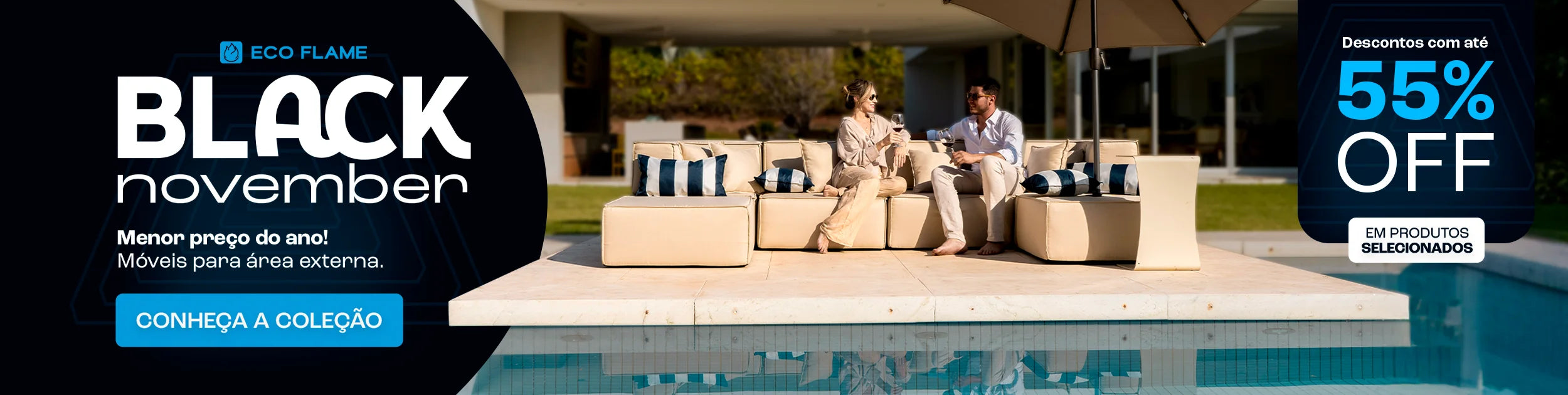 Casal sentado em um sofá cinza em uma sala de estar aconchegante. Eles estão sorrindo e segurando canecas laranja. No fundo, uma estante com livros e objetos decorativos. No topo da imagem, o texto 'Mês dos NAMORADOS' com um coração laranja, e à direita, um banner laranja com o texto 'Site até 35% OFF +30 DIAS PARA TESTAR'. O casal está usando meias coloridas e parecem estar relaxados e felizes.