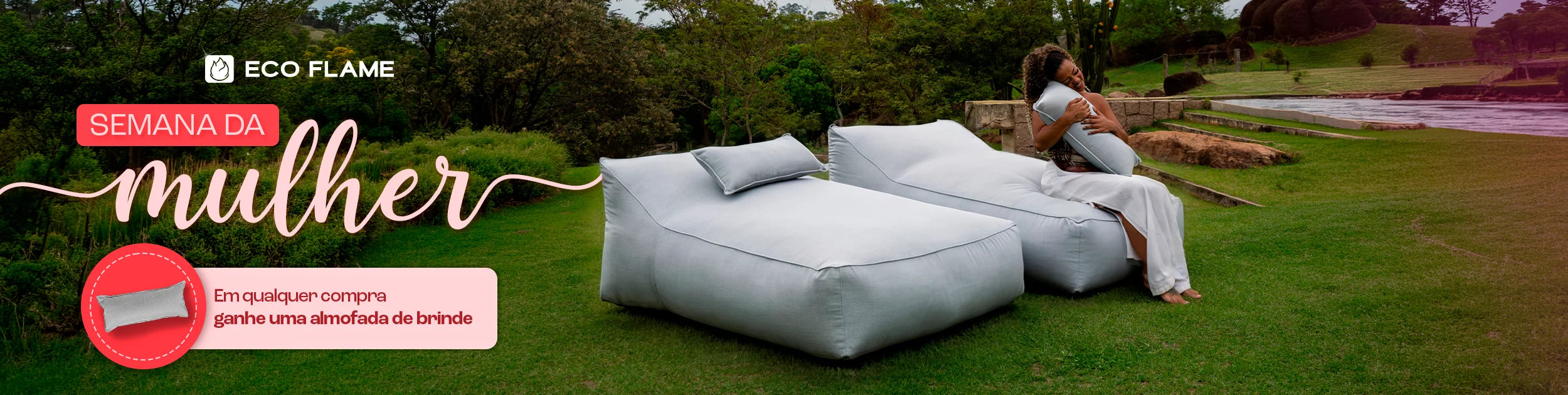 Casal sentado em um sofá cinza em uma sala de estar aconchegante. Eles estão sorrindo e segurando canecas laranja. No fundo, uma estante com livros e objetos decorativos. No topo da imagem, o texto 'Mês dos NAMORADOS' com um coração laranja, e à direita, um banner laranja com o texto 'Site até 35% OFF +30 DIAS PARA TESTAR'. O casal está usando meias coloridas e parecem estar relaxados e felizes.